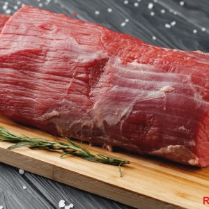 Beef tenderloin on wooden board on wooden table